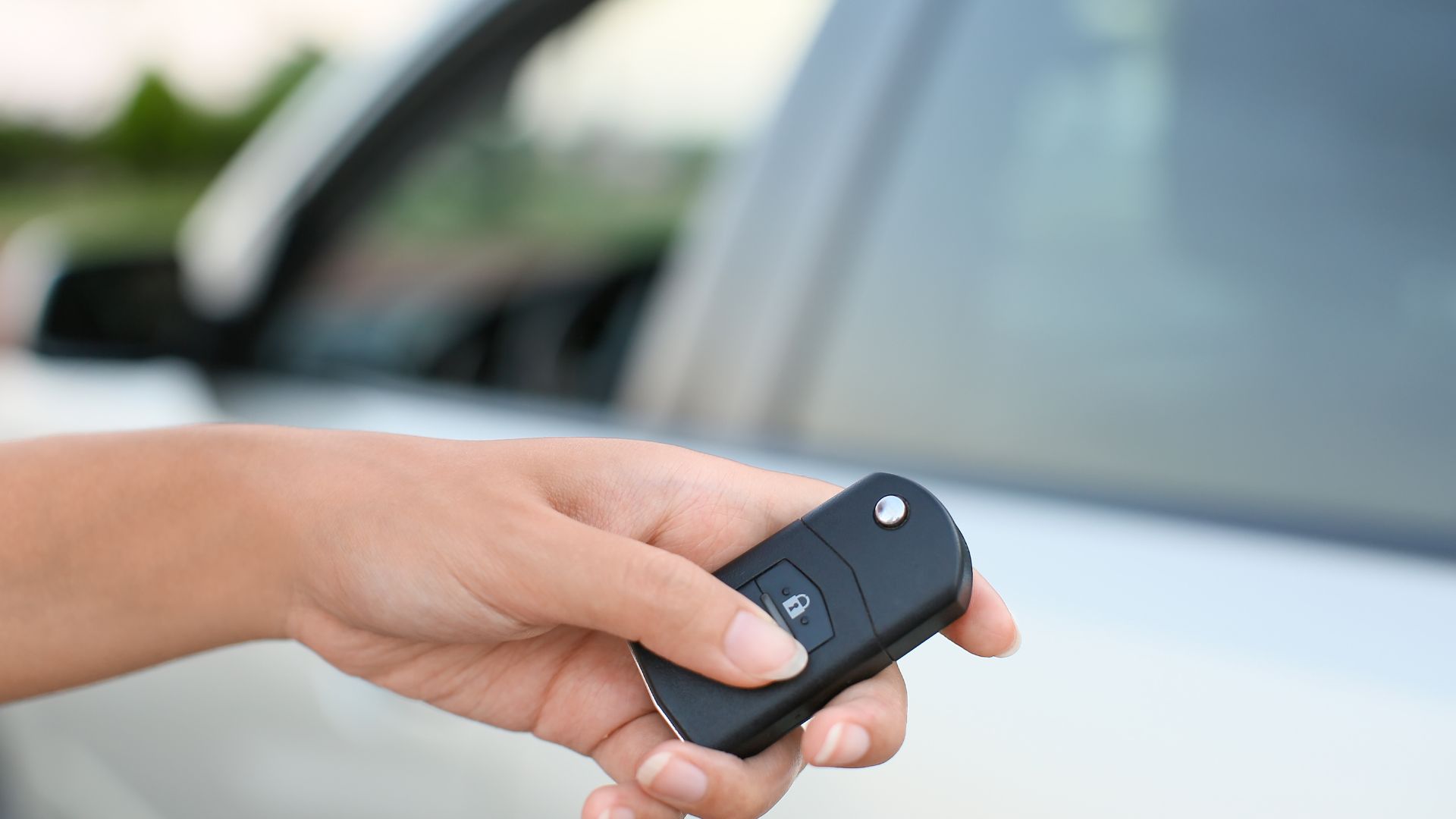 A person holding a car key in their hand