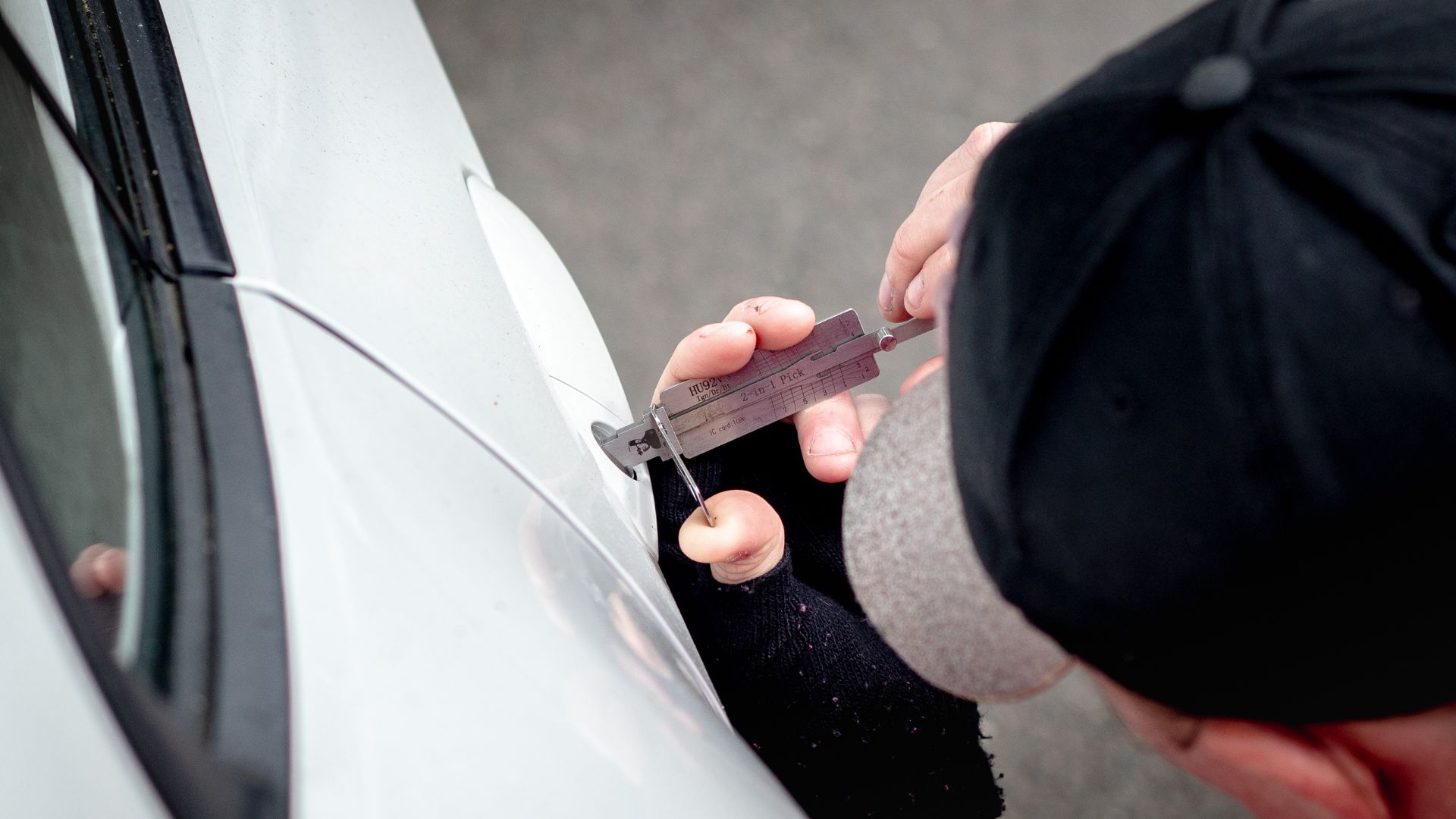 A person holding a piece of tape near a car