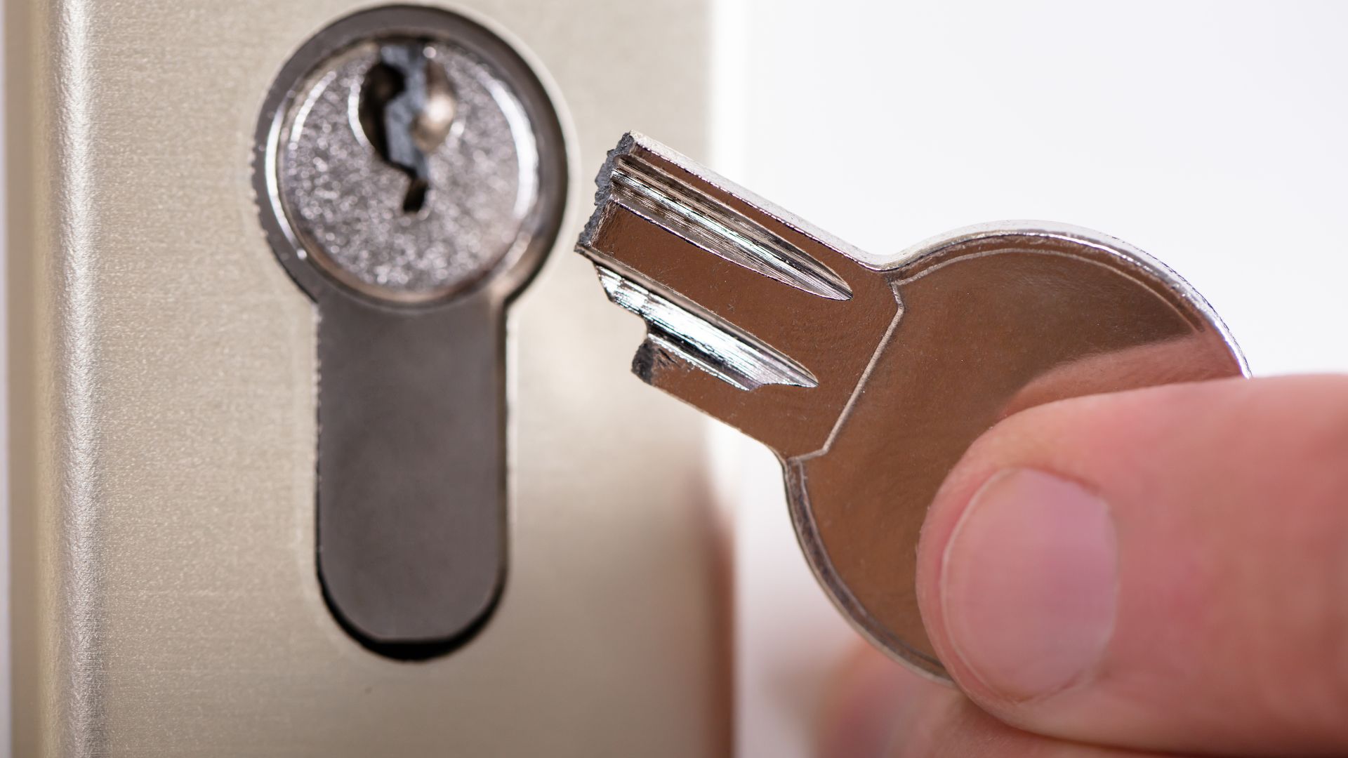 A close up of a person opening a door with a key